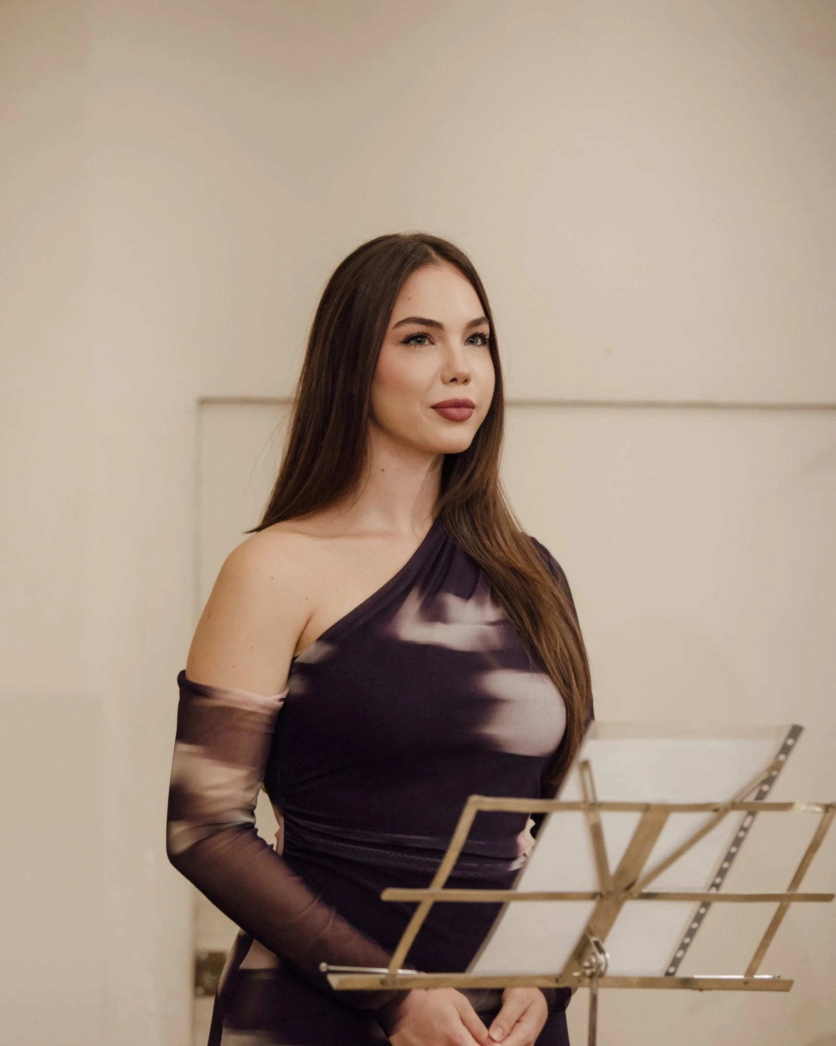 Rocío Hernández con vestido lila, de pie junto al atril, antes de cantar